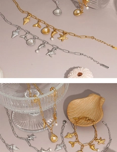 Close-up of ocean-themed starfish and shell charms on gold and silver chain bracelets