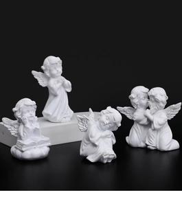 Detailed view of four white resin angel figurines in prayer and sleeping poses