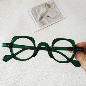Detailed view of dark green transparent round glasses with subtle geometric edges