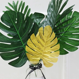 Artificial Monstera and palm leaves set with a golden leaf for wedding decoration