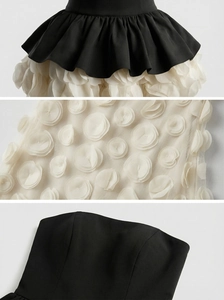 Close-up of 3D floral appliques and sheer mesh texture on monochrome evening dress