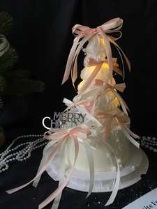 Detail of ribbon Christmas tree with pink bows, pearls, and LED warm glowing lights