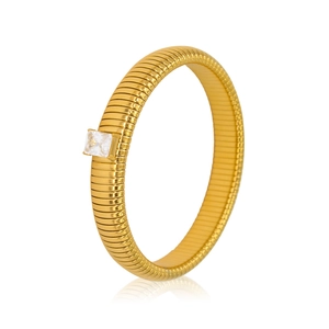 Macro shot of gold textured ring featuring a square clear zircon stone in retro style