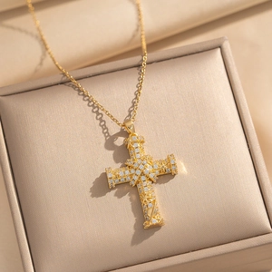 Golden cross pendant necklace with zircon inlay and star relief in a luxury jewelry box