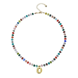 Detail of colorful beaded necklace with golden bubble letter O pendant and heart charm