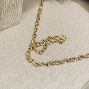 Close-up of elegant gold chain strap with metallic luster on gray wood background