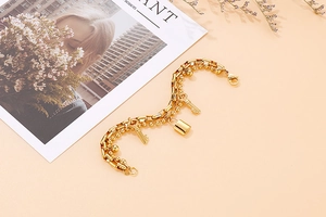 Close-up of double-layer gold titanium steel bracelet with key and padlock charms