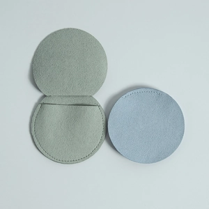 Minimalist circular microfiber jewelry pouches in soft light green and pale blue colors