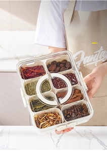 Handheld view of 8-compartment food-grade organizer storing various dried spices