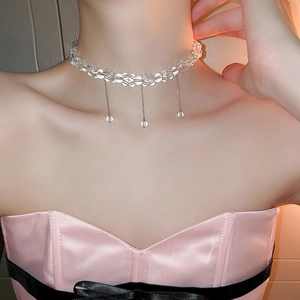 Close-up of a sparkling clear glass bead choker with silver chain tassels on model