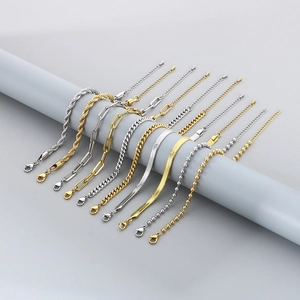 Set of gold and silver titanium steel chains displayed on a minimalist gray holder