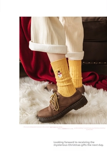 Détail d'une chaussette de Noël jaune avec broderie bonhomme de neige et maille côtelée