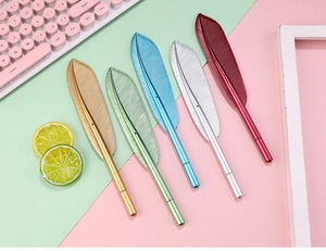 Detailed top view of five colorful metallic feather-shaped pens on a desk setup