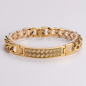 Polished gold stainless steel Cuban link bracelet with Meander pattern engraving