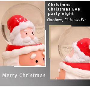 Detailed views of a Christmas crystal ball with Santa Claus figurines and red base