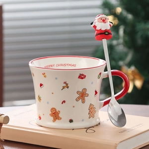 Detail of Christmas ceramic mug with gingerbread patterns and Santa Claus spoon topper