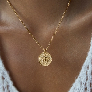 Detailed view of an 18K gold-plated coin pendant featuring an embossed bee design