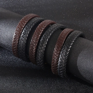 Macro view of woven leather bracelets in black and dark brown with magnetic clasp details