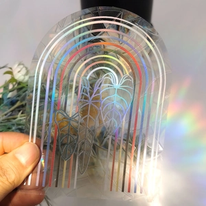Detailed view of rainbow suncatcher film with arch and leaf patterns creating prism light effects