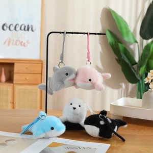 Close-up of soft plush ocean animal keychains including whale and seal on a wooden table