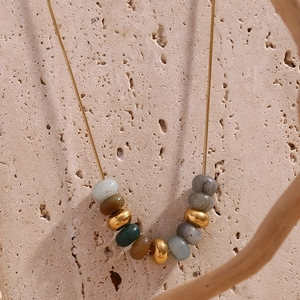 Gros plan sur une chaîne serpent dorée 18 carats avec des perles en pierre naturelle colorée