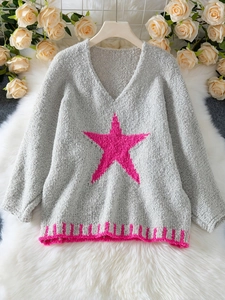 Details der Stricktextur des grauen V-Ausschnitt-Pullovers mit rosa Sternenmuster