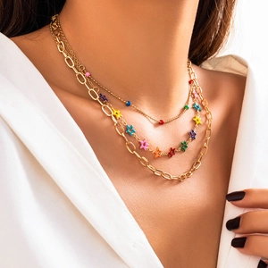 Detailed view of layered gold necklace with colorful star charms and enamel beads