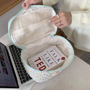 Floral cotton makeup bag with internal mesh pocket showing spacious storage capacity