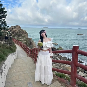 White two-piece vacation set featuring an off-shoulder ruffled top and lace maxi skirt