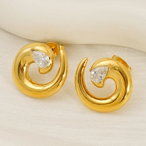 Detailed macro view of spiral gold-plated stud earrings with pear-cut cubic zirconia