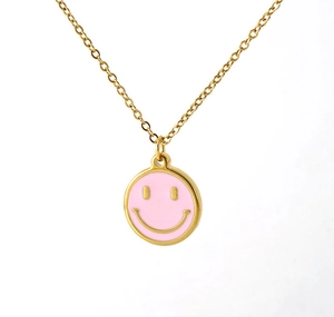 Détail du pendentif smiley rond en émail rose sur une chaîne en acier inoxydable doré