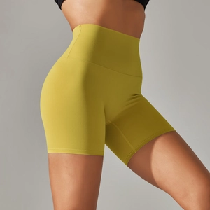 Close-up of bright yellow high-waisted yoga shorts showing tummy control fit and stretch