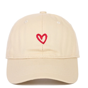 Detail of red heart embroidery on a beige cotton canvas baseball cap with neat stitching
