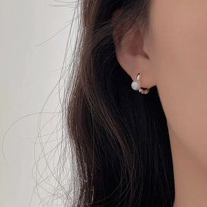 Elegant 925 sterling silver pearl hoop earrings worn by a model for a minimalist look