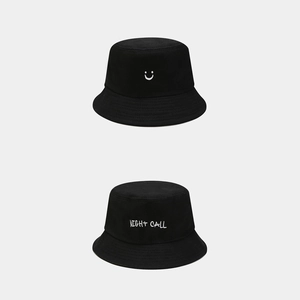 Detail of black cotton bucket hats featuring smiley face and Night Call embroidery