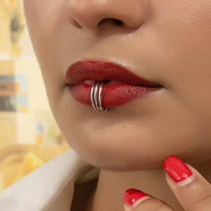 Macro close-up of a silver triple-layer lip ring clip on a model showing modern chic style