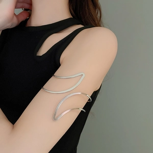 Gros plan d'un bracelet de bras feuille évidé en argent minimaliste sur un mannequin