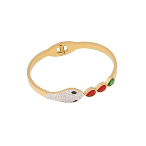 Gold snake bracelet with pavé crystals and red and green marquise gems on white background
