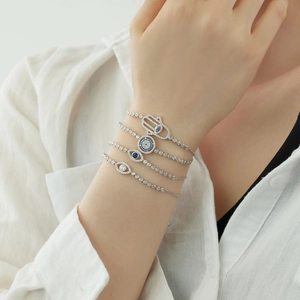 Detail of silver Hamsa Hand and Evil Eye bracelets set with blue gems and diamonds