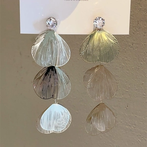 Detailed view of layered hollow ginkgo leaf earrings with tassels and zircon stones