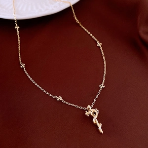 Macro shot of gold dragon pendant with inset zircon on vintage cross chain design