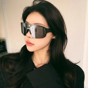 Close-up of model wearing black sports sunglasses with silver mirrored lenses for cycling