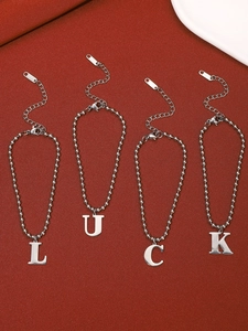 Detail of four-piece silver stainless steel anklet set with LUCK letter charms