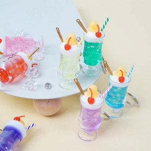 Portachiavi a forma di tazza di bevanda colorata con crema, ciliegie e cubetti di ghiaccio
