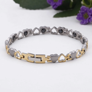 Dettaglio del bracciale a maglie a cuore in acciaio oro e argento con inserti magnetici