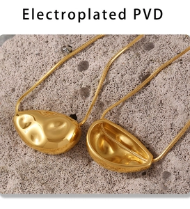 Detail of molten geometric gold pendant on a textured rock background with snake chain