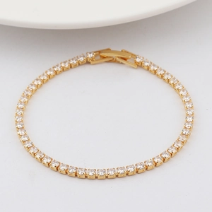 Macro detail of golden bracelet featuring square-cut zircons and a secure folding clasp