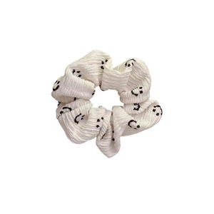 White scrunchie with black smiley faces, pleated fabric hair tie for women's hair styling