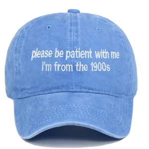 Détail macro de broderie blanche sur casquette en coton bleu délavé avec slogan vintage