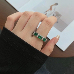 Detail of S925 silver ring featuring three emerald-cut green stones and micro-pave diamonds
